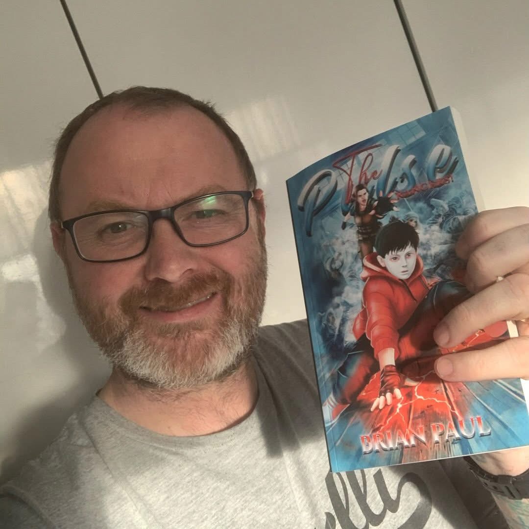 Brian Paul, the Scribe, holding his Pulse Rangers book