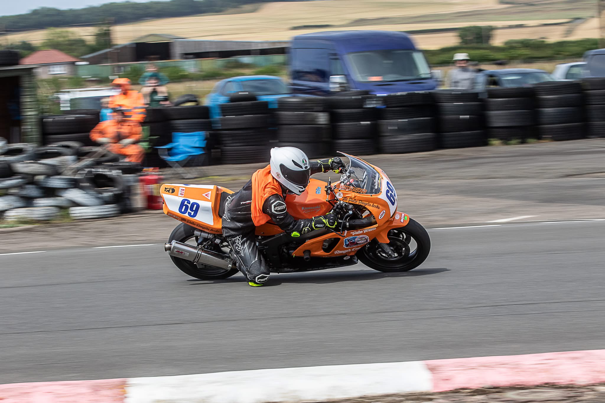 The real Xander leaning into a corner on his orange number 69 racing motorcycle